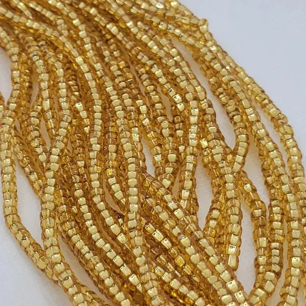 Close-up of a string of gold beads on a white background